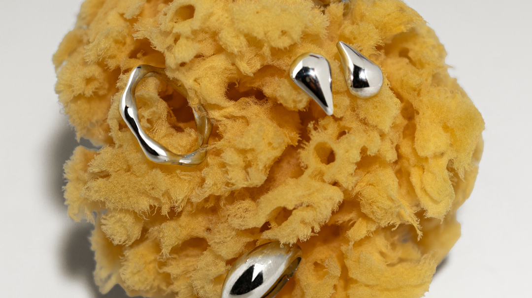 Anéis e brincos em prata 925 em cima de esponja