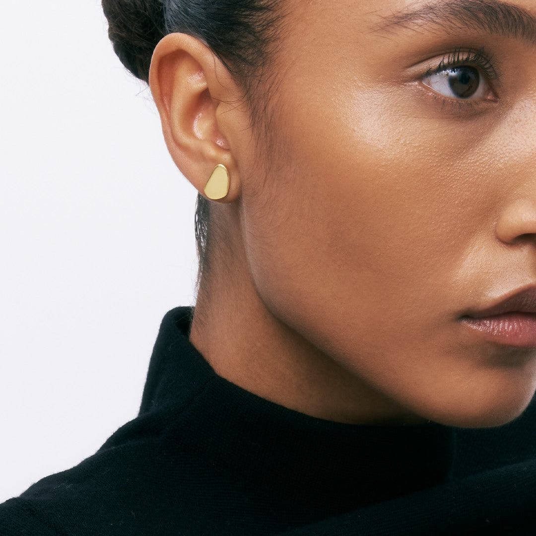 Brincos irregluares de prata 925 com banho de ouro 18K em modelo.