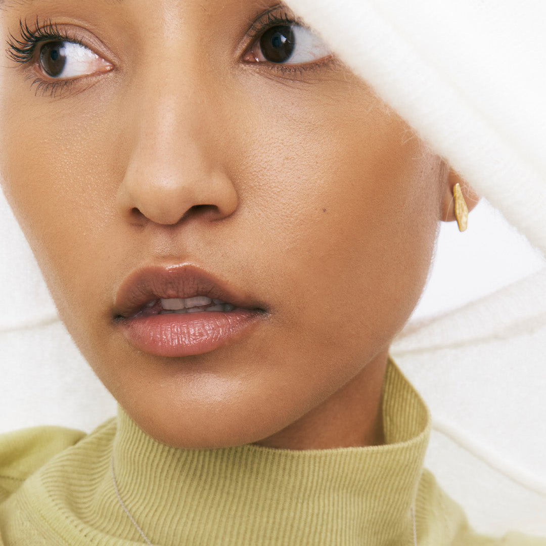 Brincos irregulares em pata 925 com banho de ouro 18k em modelo.