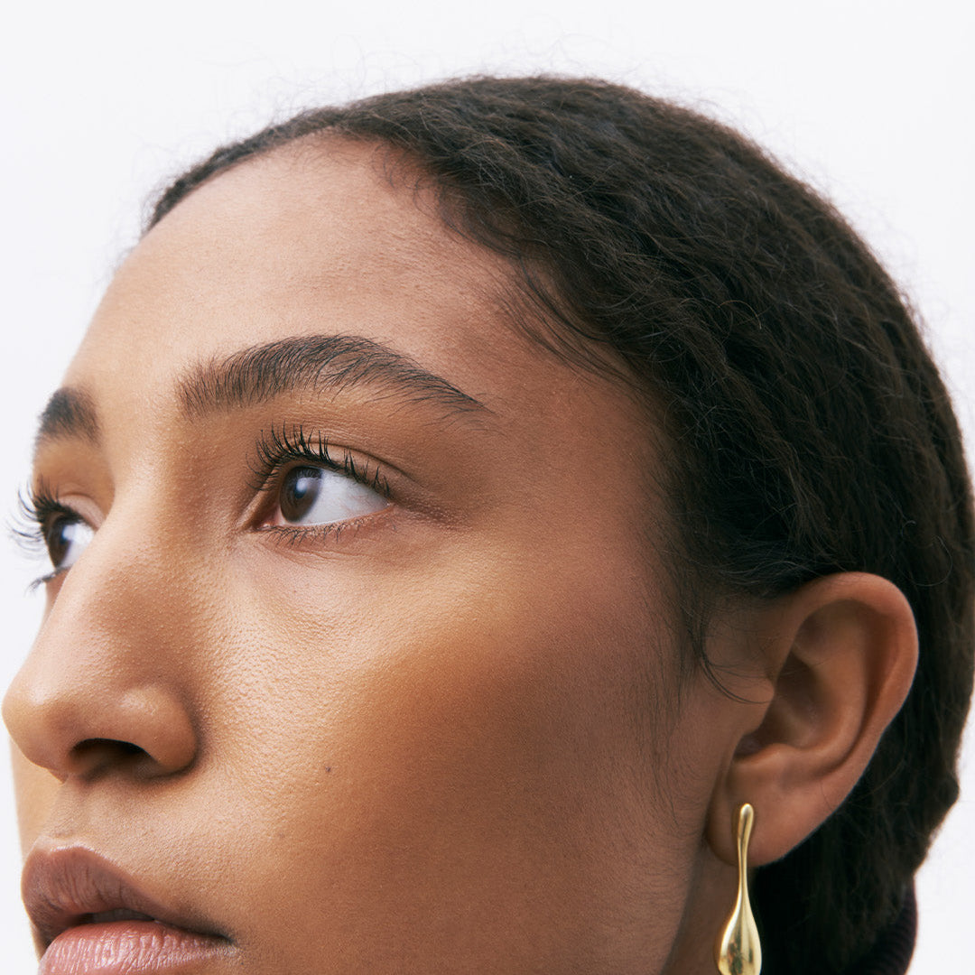 Brincos compridos em prata 925 e banho de ouro 18K em modelo.