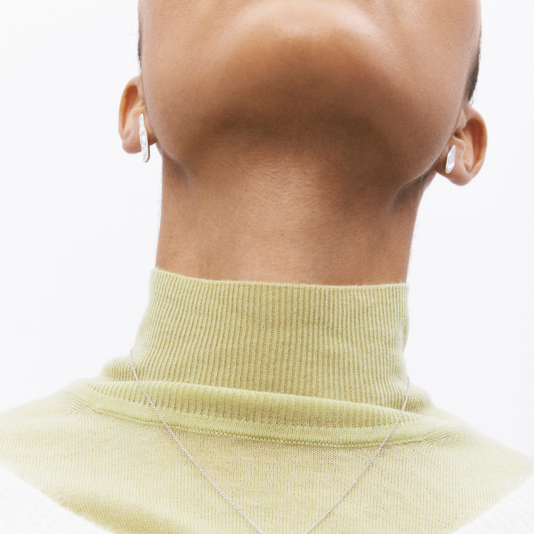 Brincos irregulares em pata 925 com banho de ródio em modelo.