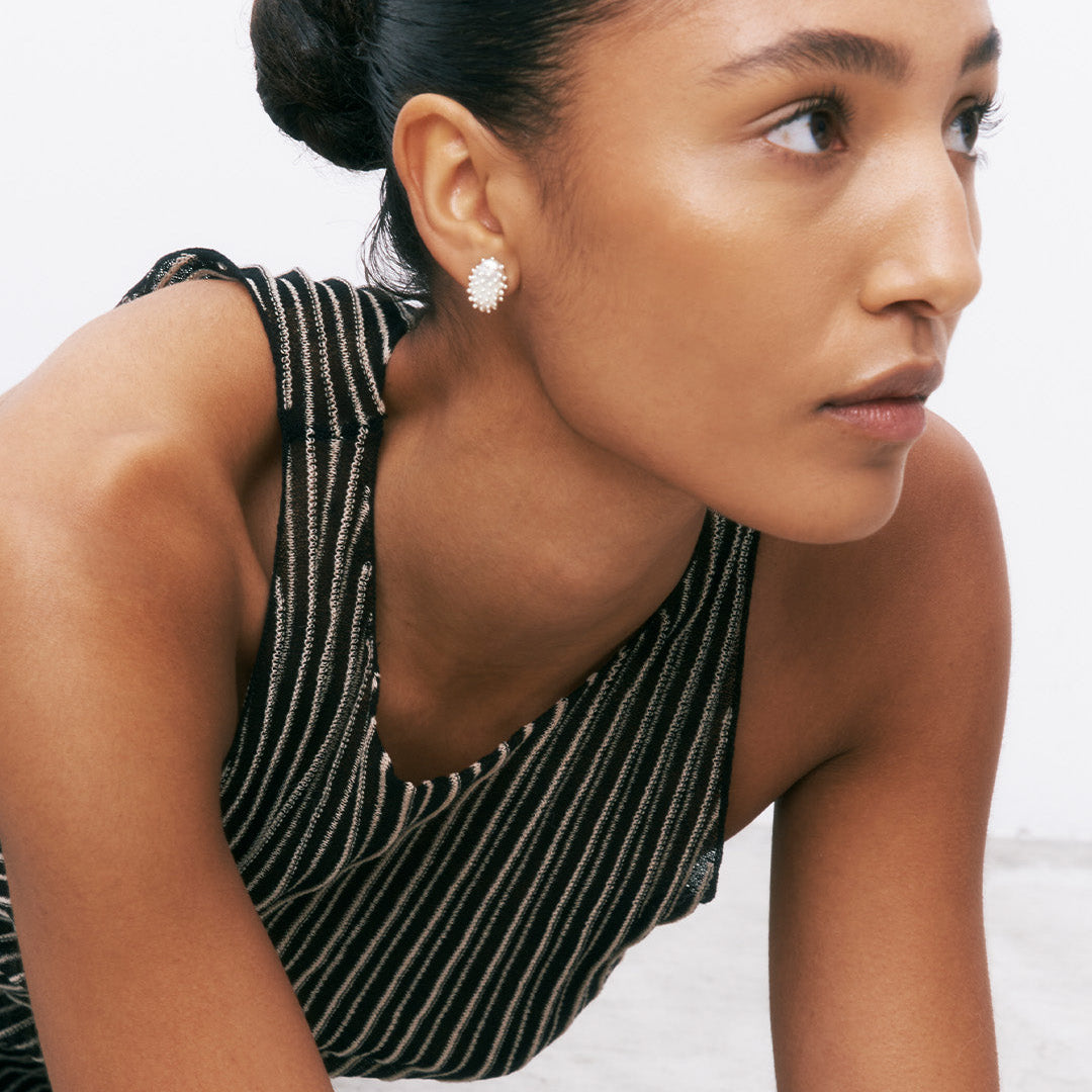 Brincos ovais com relevo em prata 925 com banho de ródio em modelo.