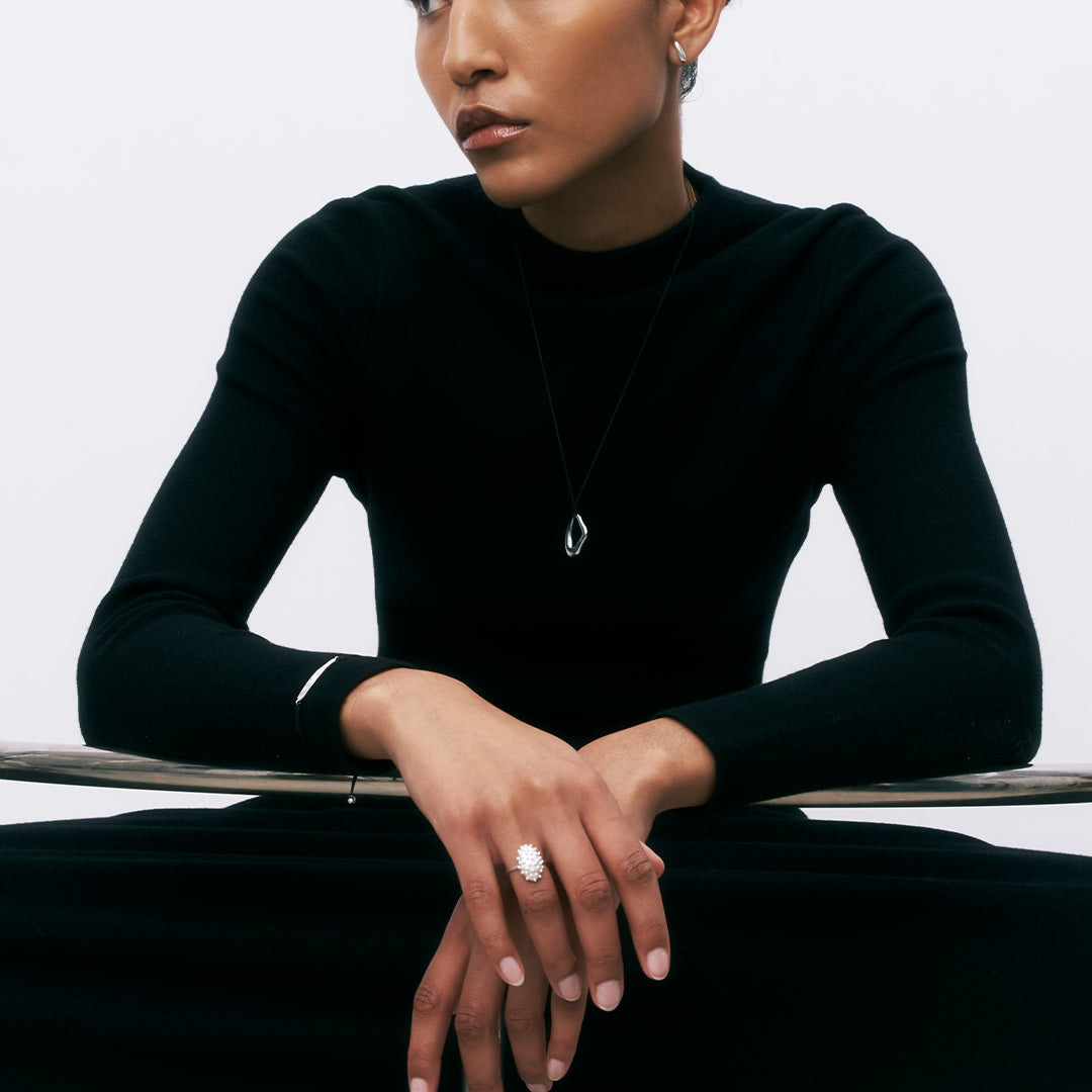 Anel oval com relevos de prata 925 com banho de ródio em modelo.