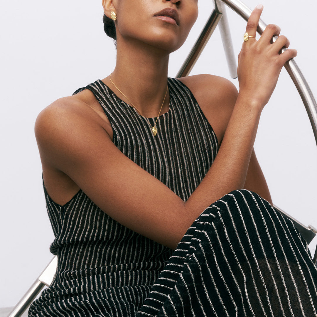 Brincos ovais com relevo em prata 925 com banho de ouro 18k em modelo.