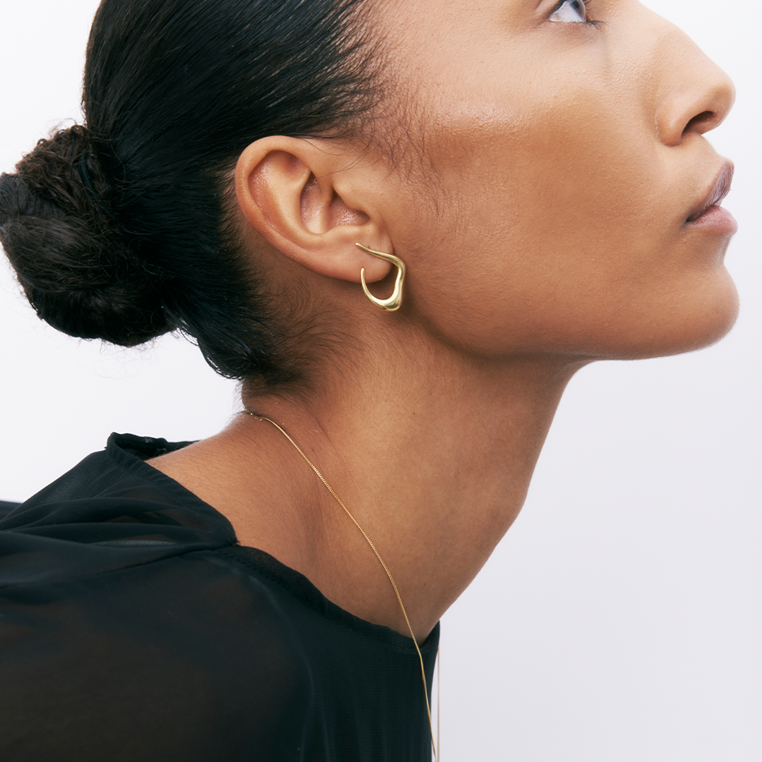 Brincos statement de prata 925 com banho de ouro 18K em modelo.