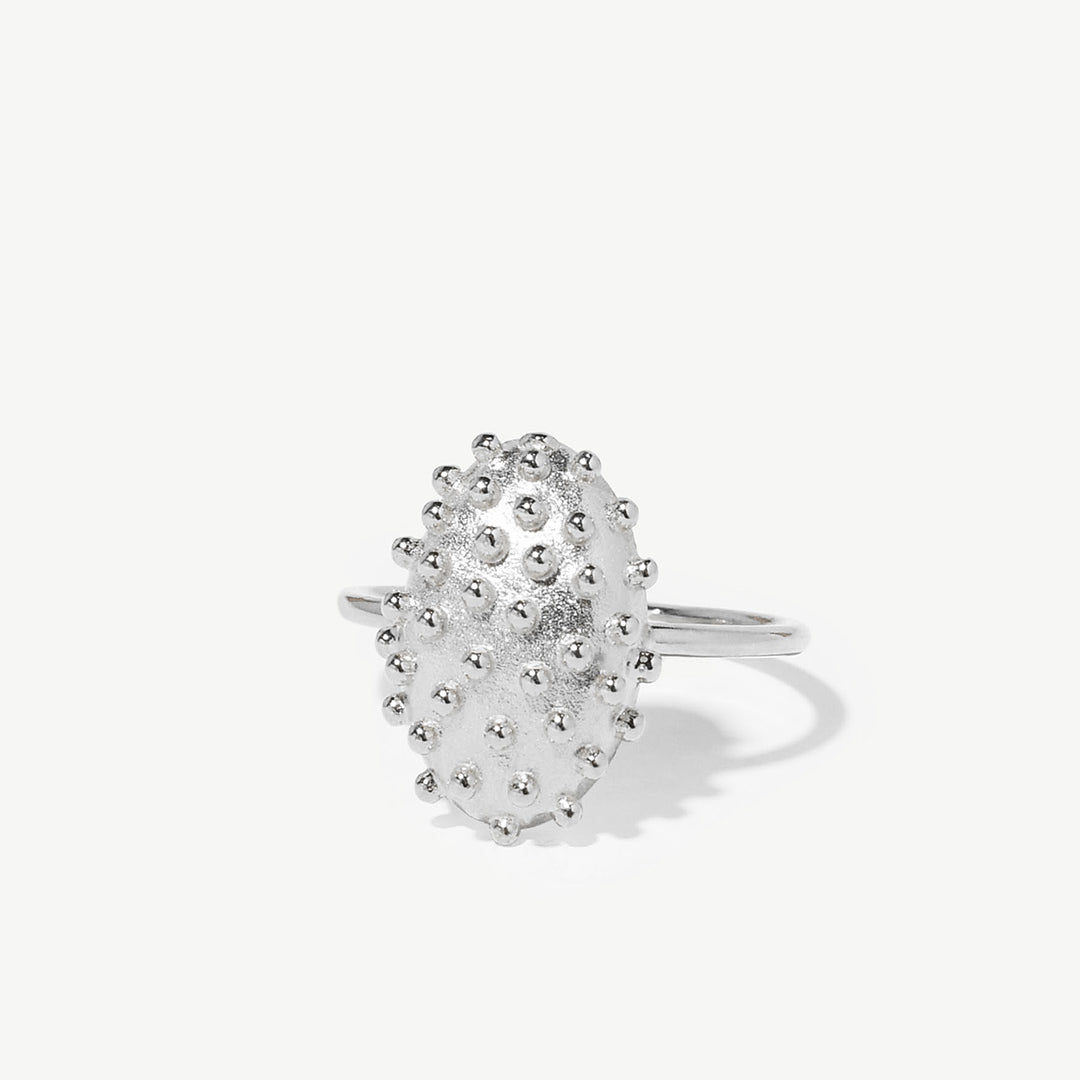 Anel oval com relevos de prata 925 com banho de ródio.