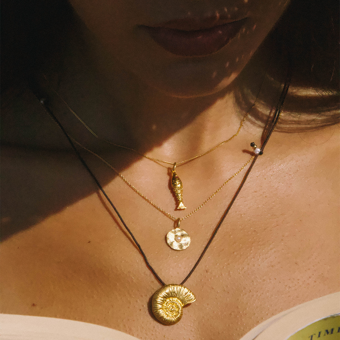 Colar com medalha de prata 925 com banho de ouro 18K e pérola em modelo.