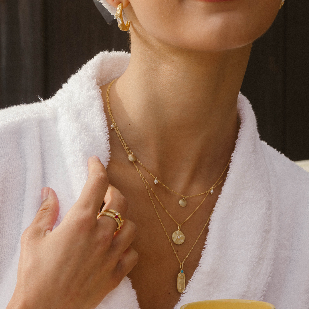 Colar com medalha de prata 925 com banho de ouro 18K e pérola em modelo.