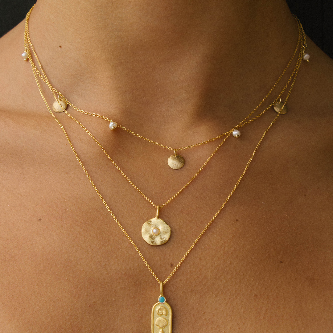 Colar com medalha de prata 925 com banho de ouro 18K e pérola em modelo.