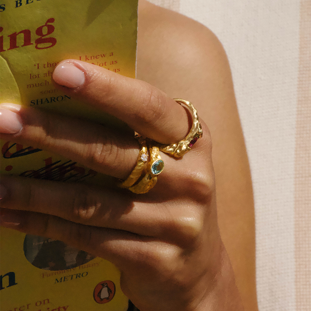 Anel texturizado statement em prata 925 com banho de ouro 18K e zircónia cúbica oval em modelo.