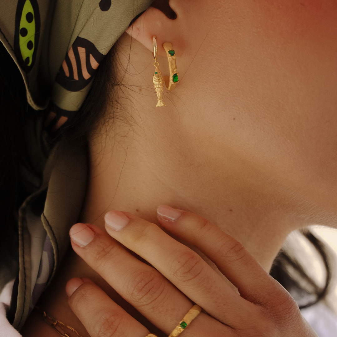 Argolas assimétricas em prata 925 com banho de ouro 18K e zircónias cúbicas em modelo.