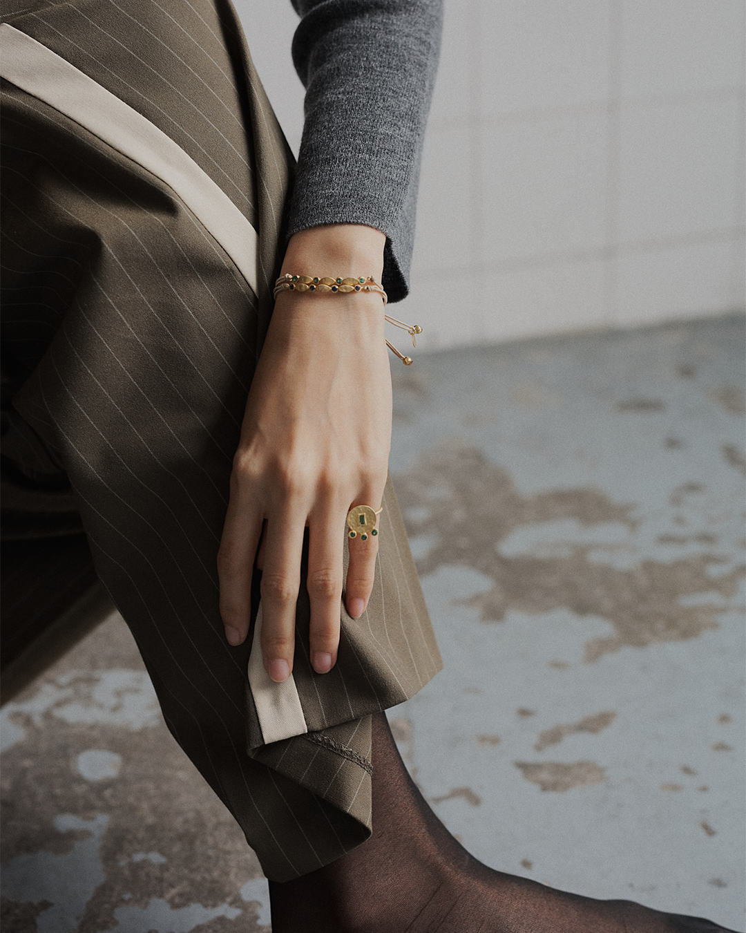 Pulseira ajustável em macramé com detalhe em prata 925 martelada com banho de ouro 18K e zircónia cúbica em modelo.