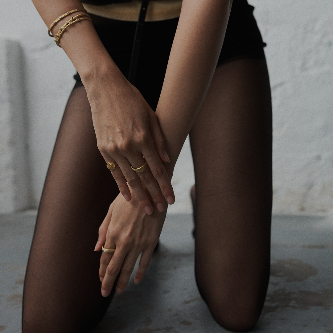 Escrava em prata 925 martelada com banho de ouro 18K e zircónias ovais em modelo.