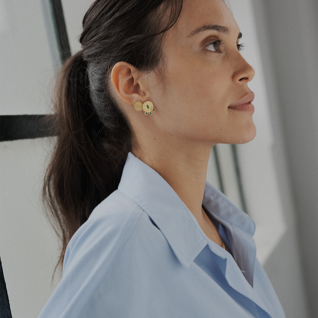 Brincos redondos martelados em prata 925 com banho de ouro 18K e zircónias cúbicas em modelo.