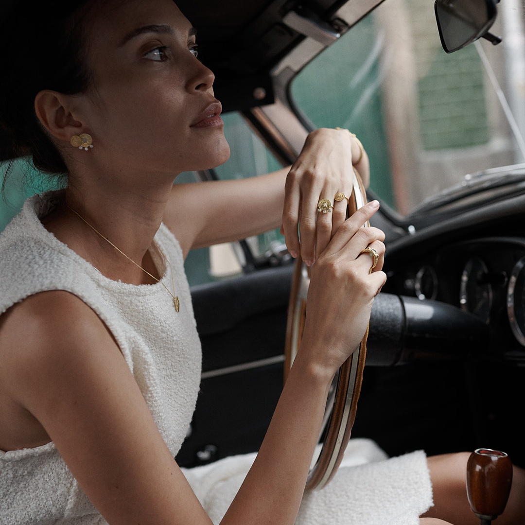 Brincos redondos martelados em prata 925 com banho de ouro 18K e zircónias cúbicas em modelo.