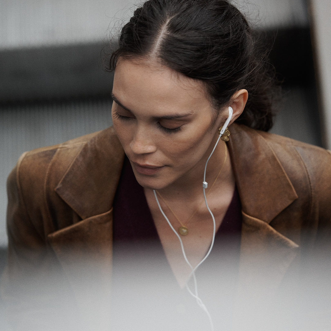 Brincos compridos articulados com detalhes redondos e relevo em prata 925 com banho de ouro 18K em modelo.