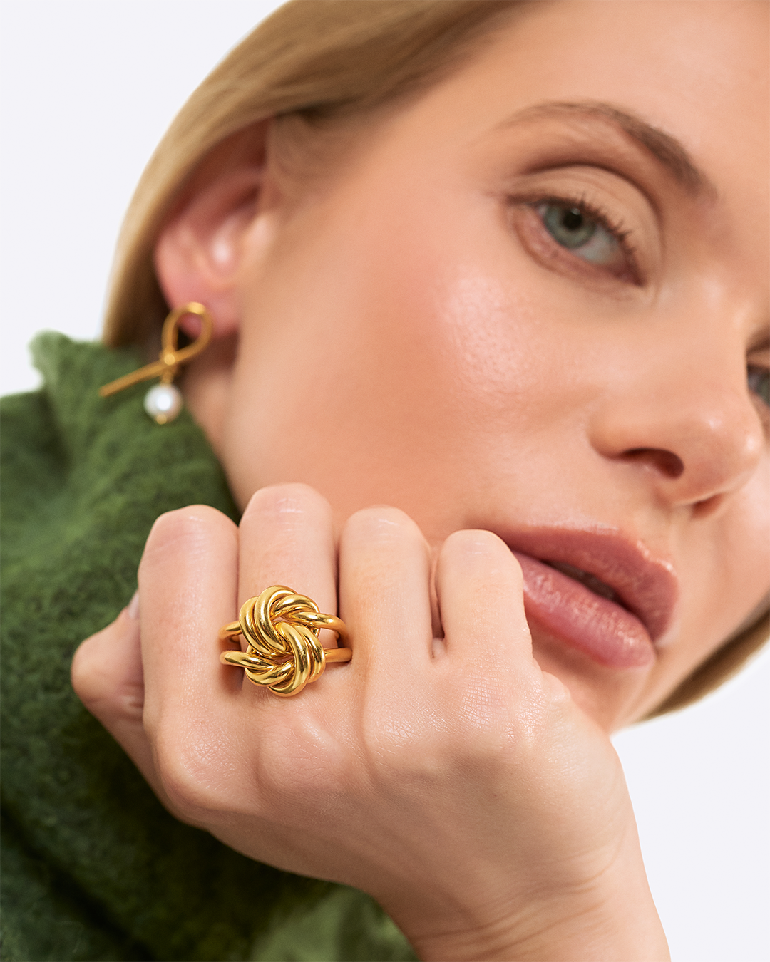 Modelo com anel Knot em prata dourada statement.