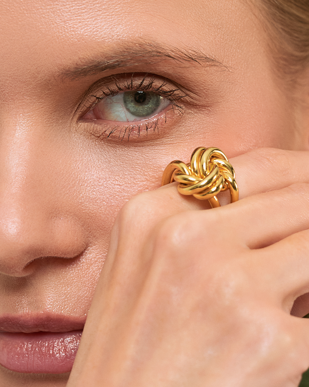 Modelo com anel Knot em prata dourada statement.