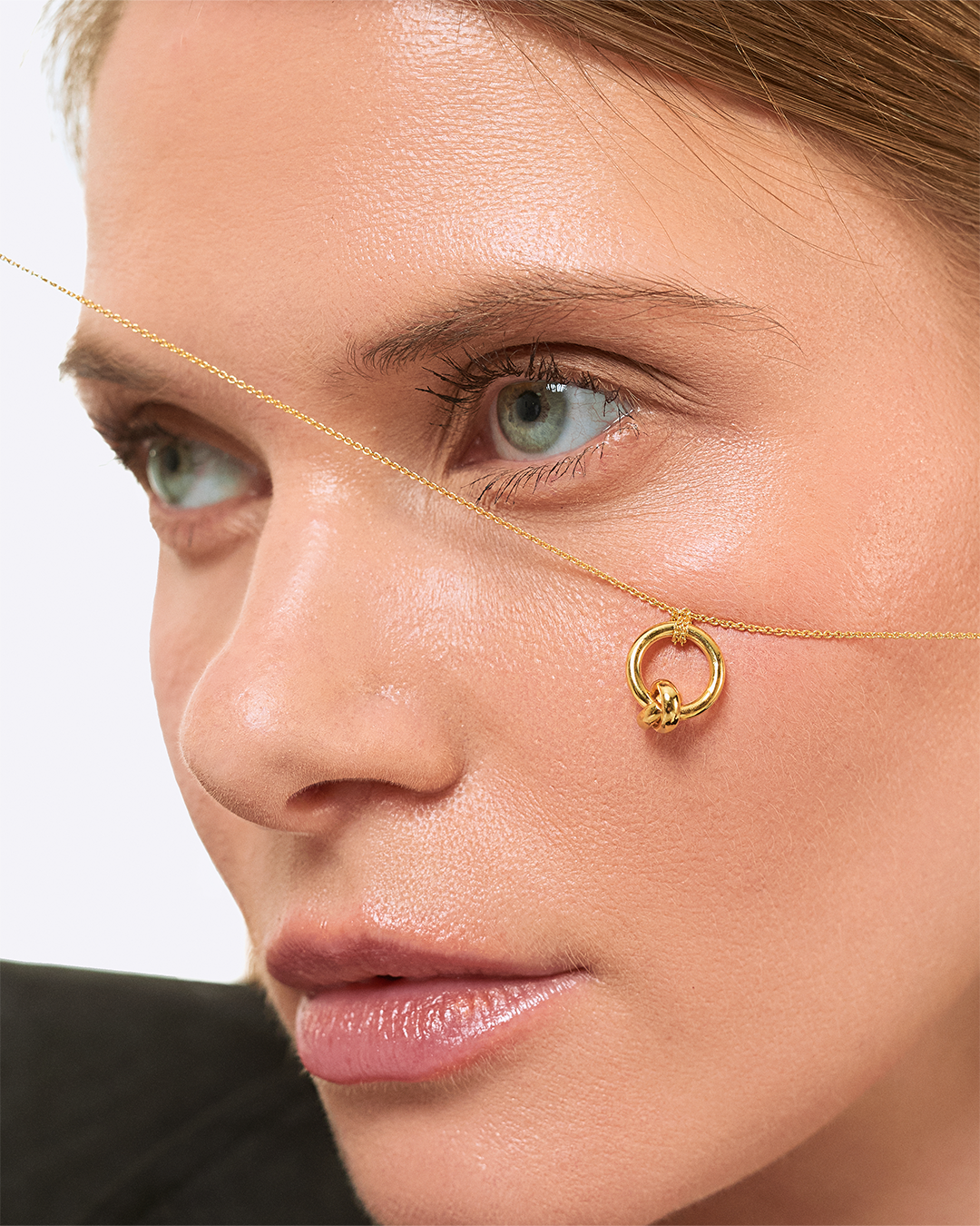 Colar com pendente de nó em prata dourada em modelo.