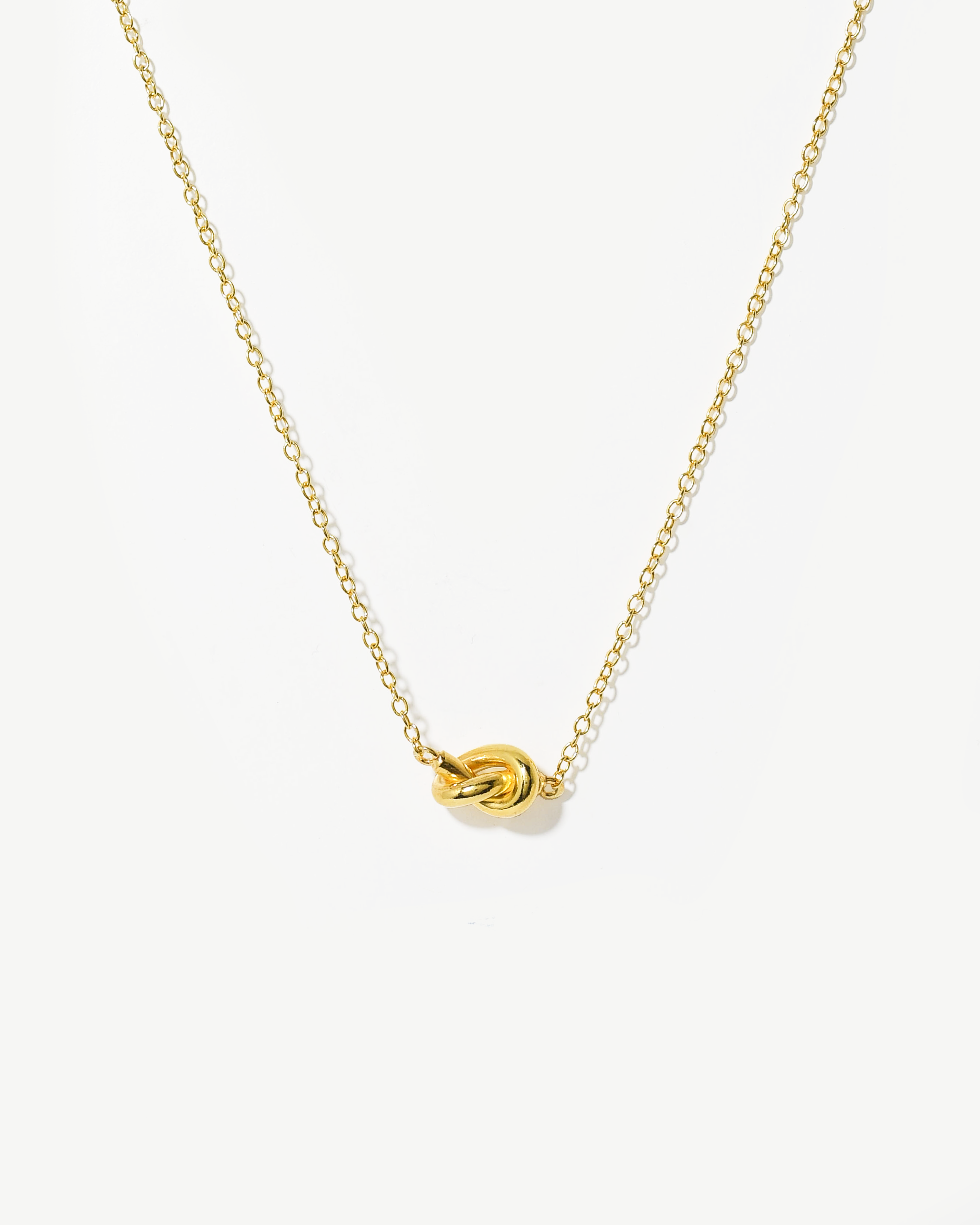 Colar com detalhe nó simples em prata dourada.