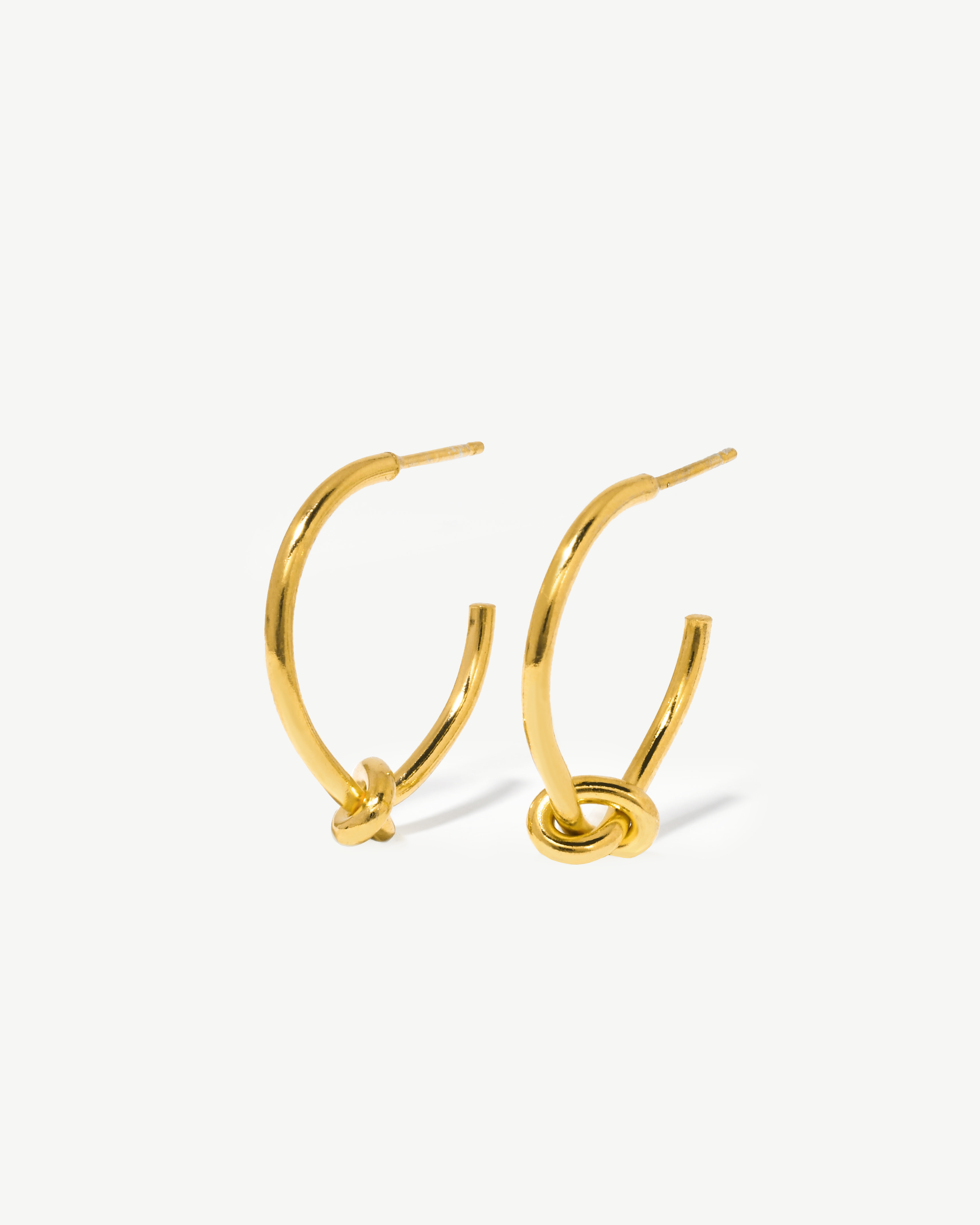 Argolas com detalhe em nó de prata dourada.