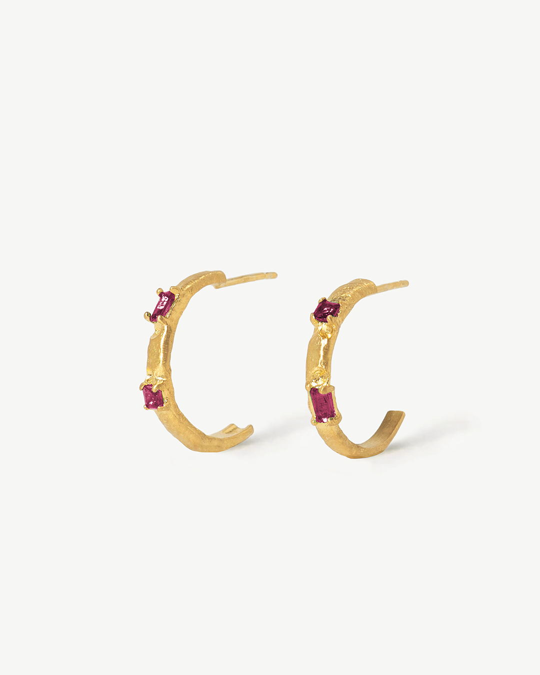 Argolas assimétricas em prata dourada com zirconias rubi