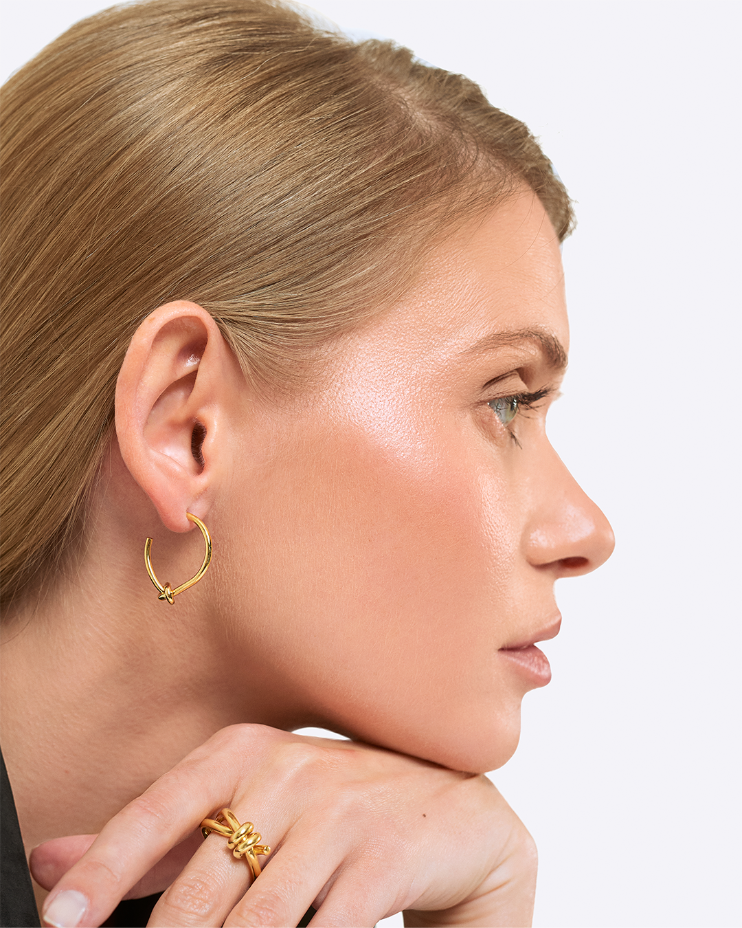 Anel entrelaçado em prata dourada em modelo.