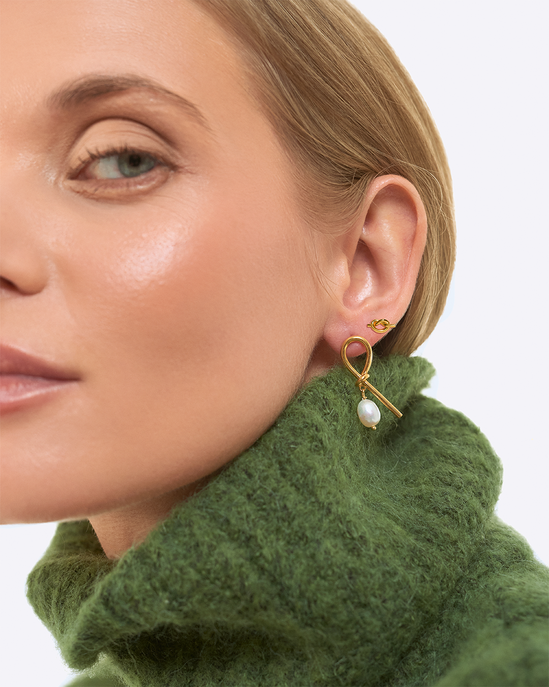 Modelo com brincos da coleçao knot em prata dourada.