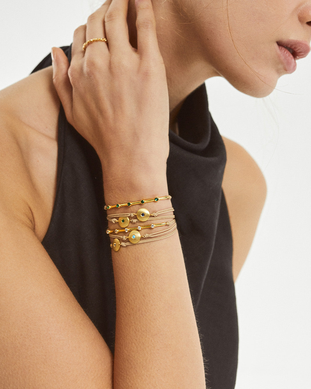 Pulseira ajustável em algodão com pendente em prata 925 com banho de ouro 18K e zircónia cúbica em modelo.