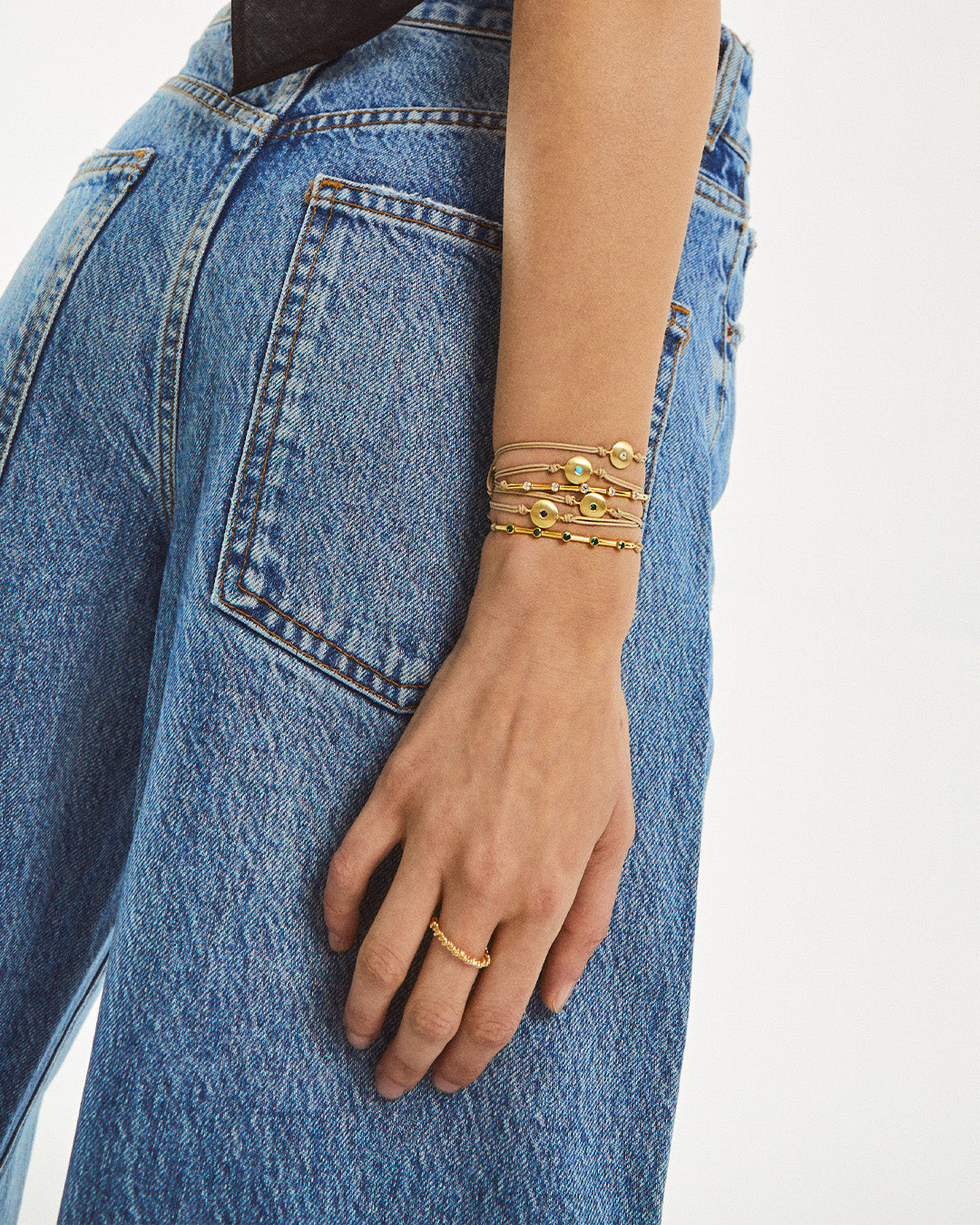 Pulseira ajustável em algodão com pendente em prata 925 com banho de ouro 18K e zircónia cúbica em modelo.