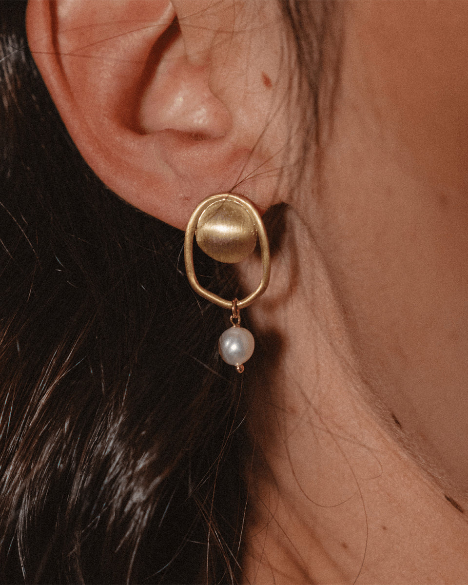 Brincos dourados com pérola