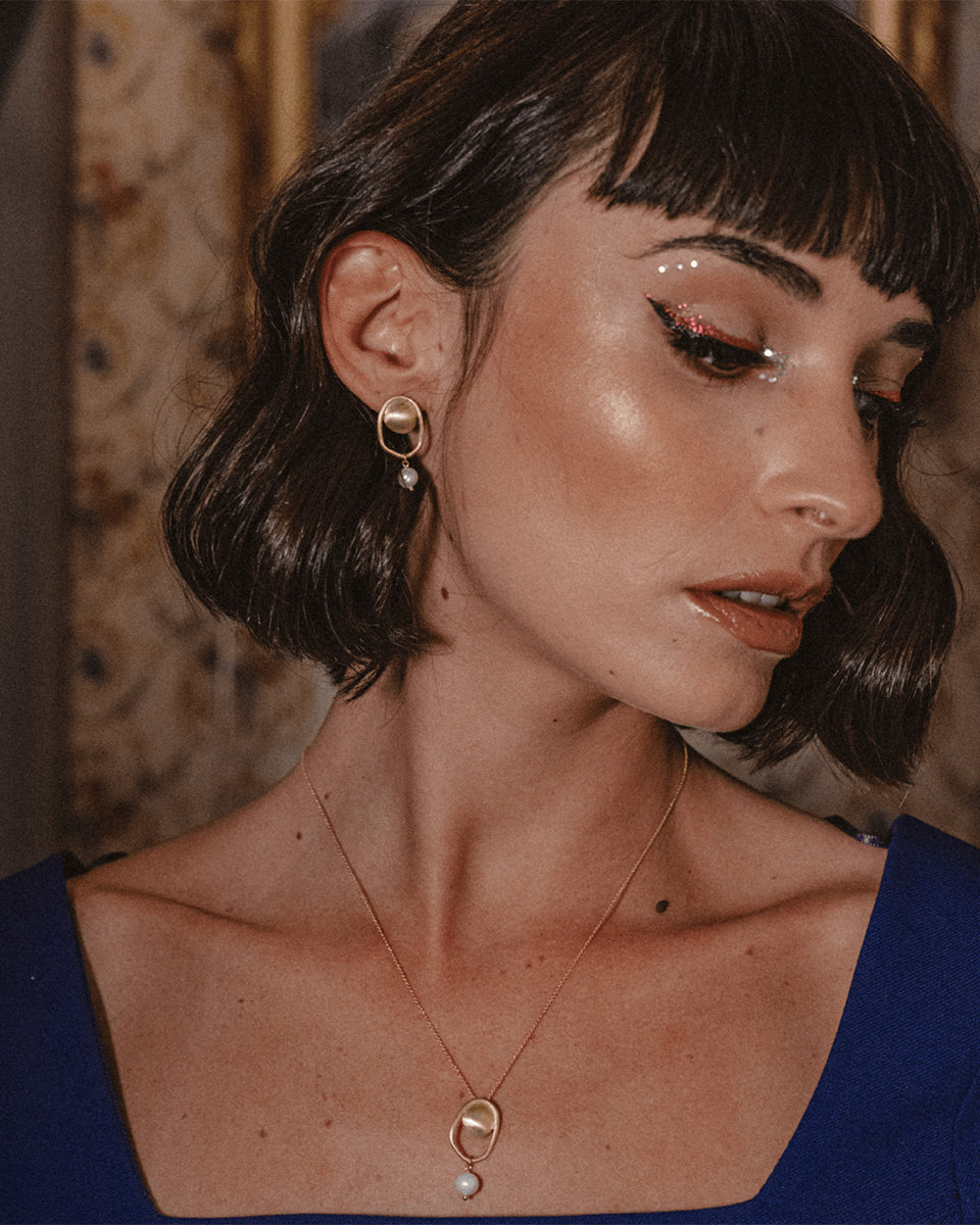 Brincos dourados com pérola