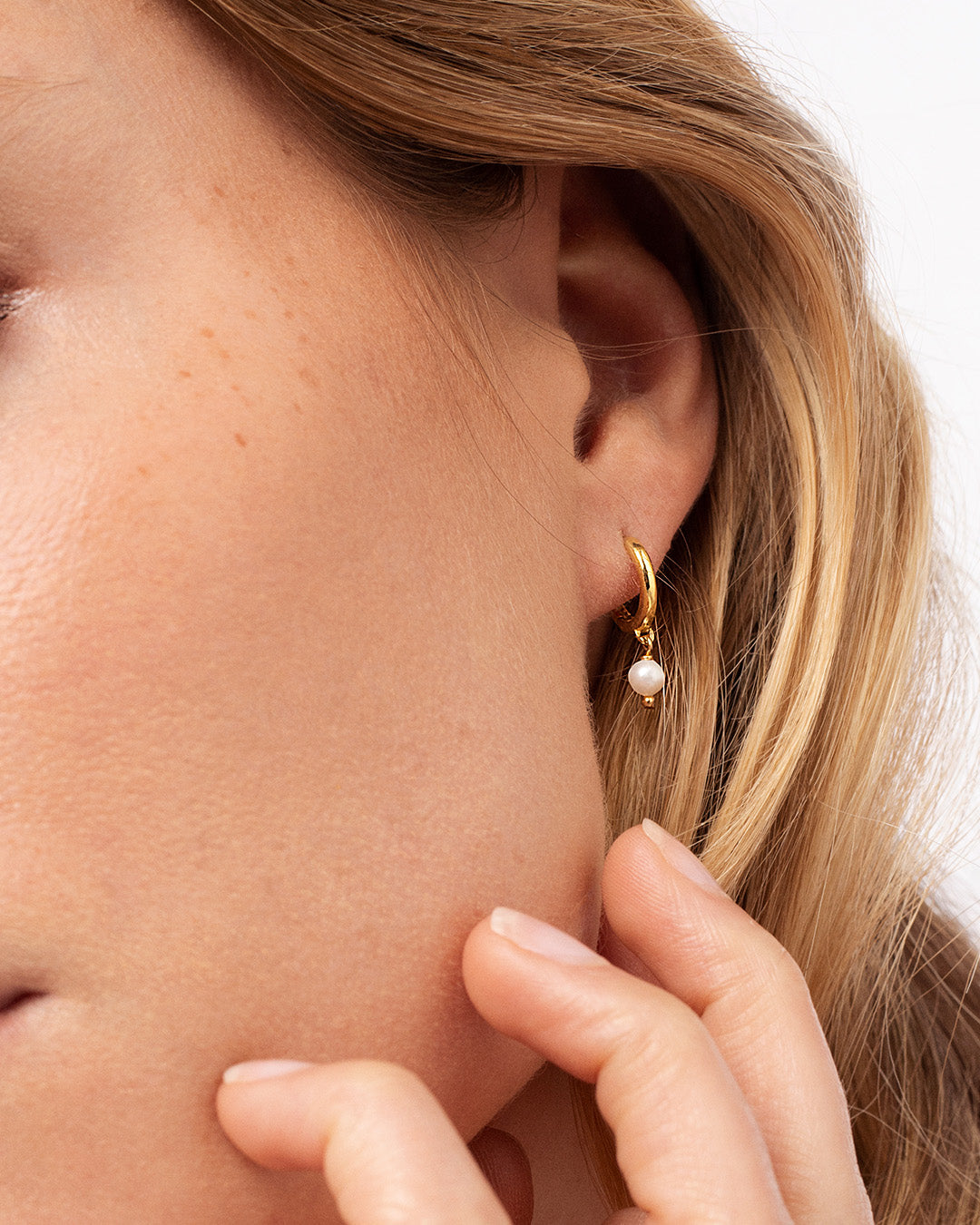 Argolas em prata 925 e banho de ouro 18K com pendentes em pérola natural em modelo.