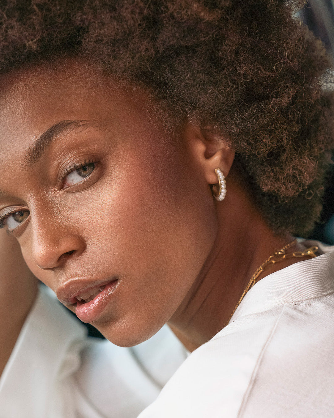 Argolas em prata 925 com banho de ouro 18K e pérolas naturais em modelo.