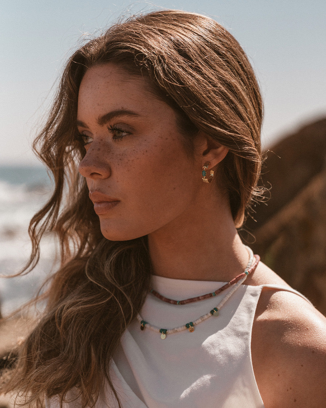 Argolas em prata 925 com banho de ouro 18K e pedras hidrotermais coloridas em modelo.