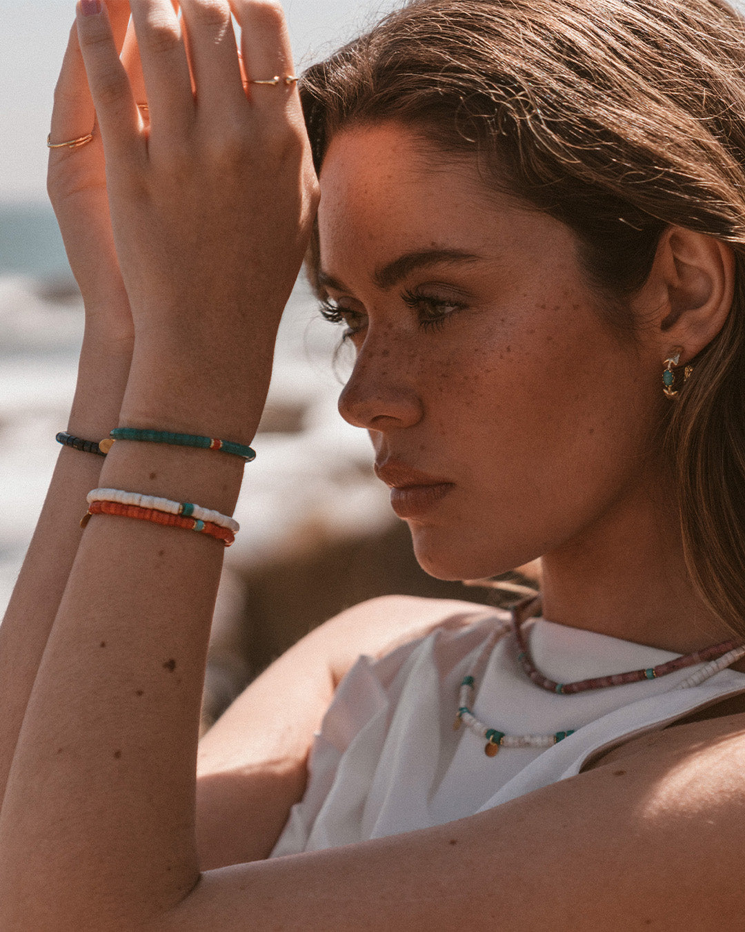 Argolas em prata 925 com banho de ouro 18K e pedras hidrotermais coloridas em modelo.