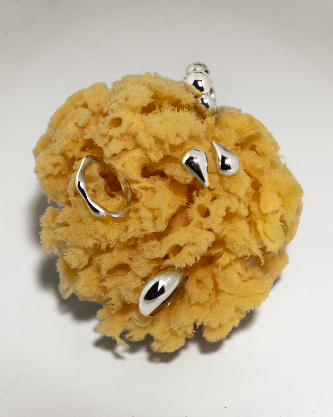 Anéis e brincos em prata 925 em cima de esponja