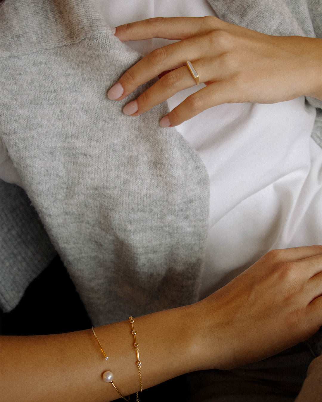 Anel ajustável em prata 925 com banho de ouro 18K e madrepérola em modelo.