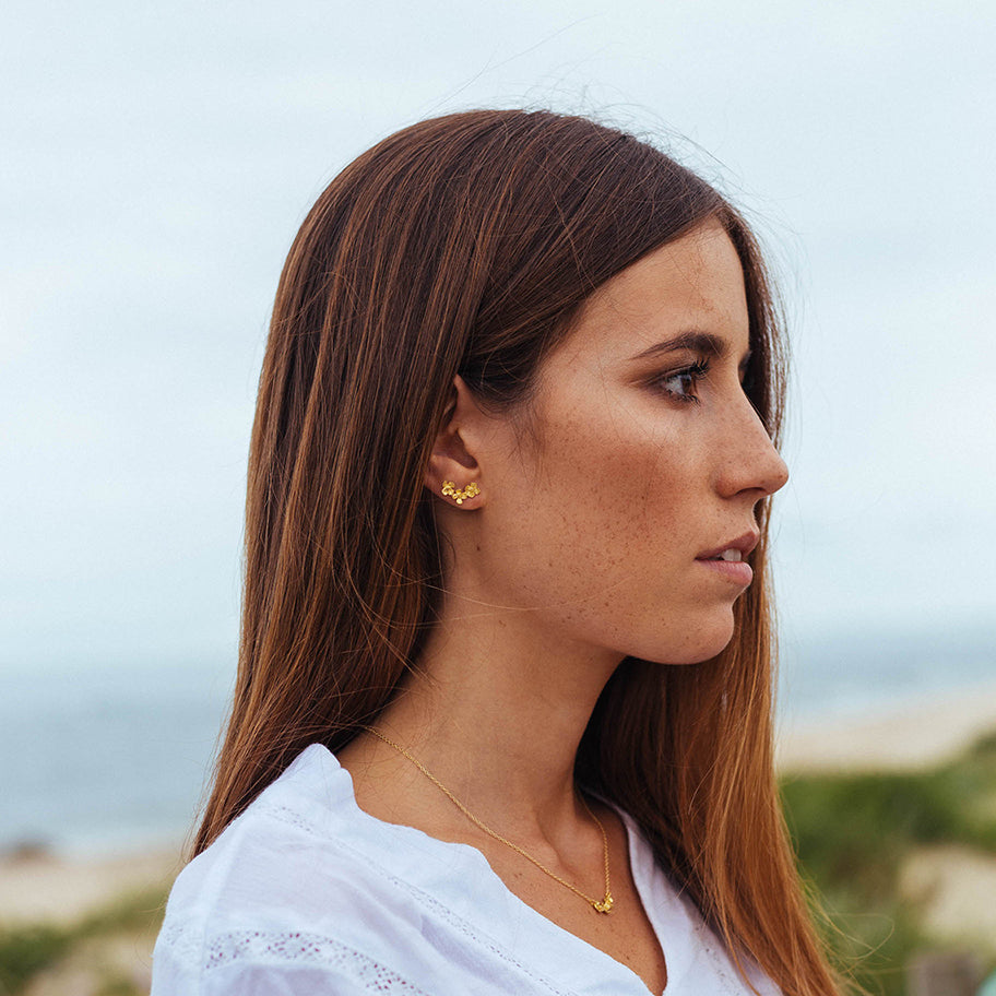 Modelo com set de colar e brincos flores.