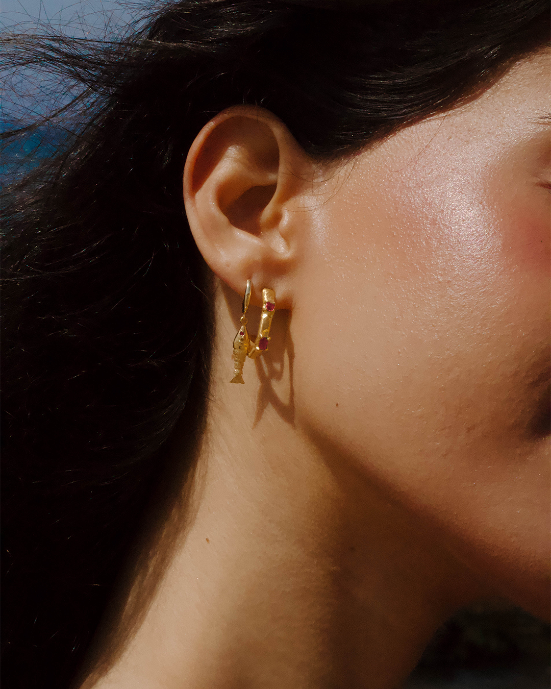 Argola singular com pendente peixe em prata 925 com banho de ouro 18K e zircónia cúbica rosa em modelo.