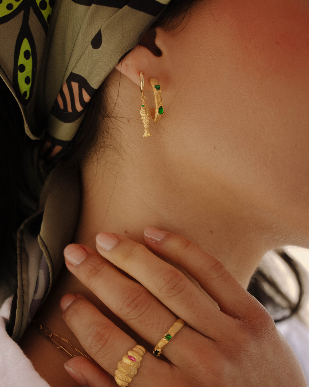 Anel texturizado em prata 925 com banho de ouro 18K e zircónia cúbica rosa em modelo.