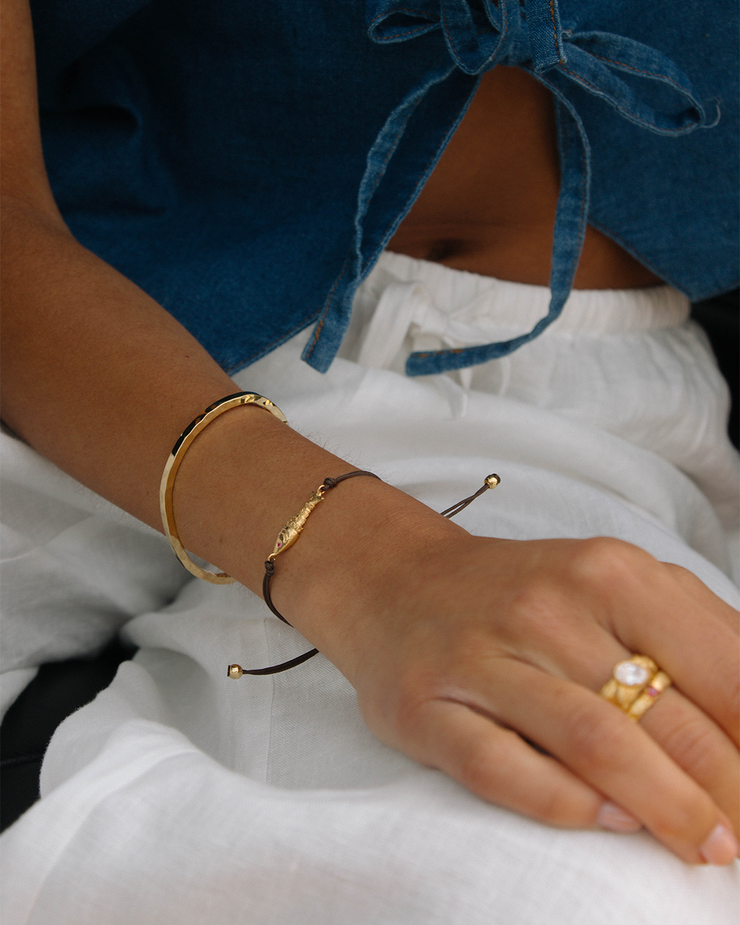 Pulseira em corda com peixe em prata 925 com banho de ouro 18K e zircónias em modelo.