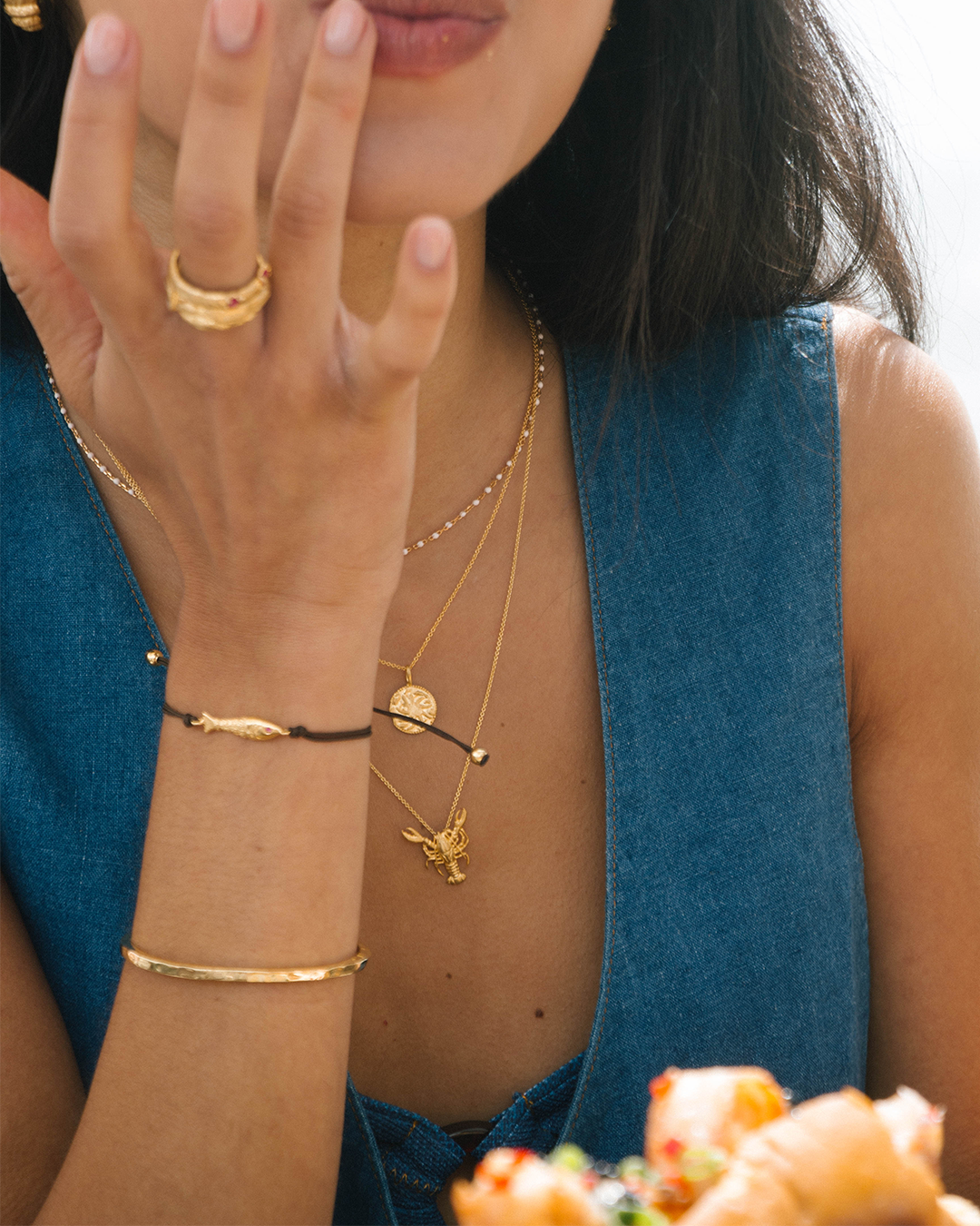 Pulseira em corda com peixe em prata 925 com banho de ouro 18K e zircónias em modelo.