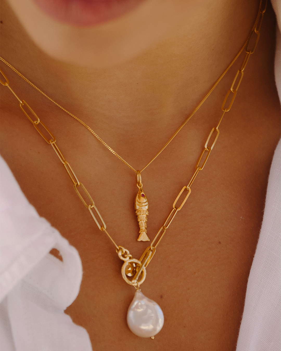 Colar com peixe em prata 925 com banho de ouro 18K e zircónias cúbicas em modelo.