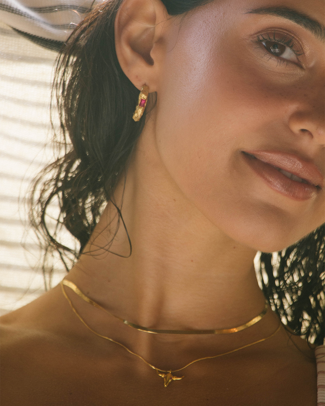 Argolas statement em prata 925 com banho de ouro 18K e zircónia cúbica rosa em modelo.